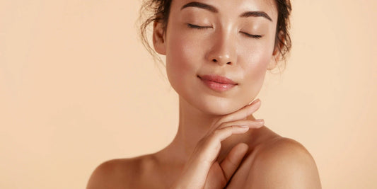 A woman with healthy glowing skin touching her face